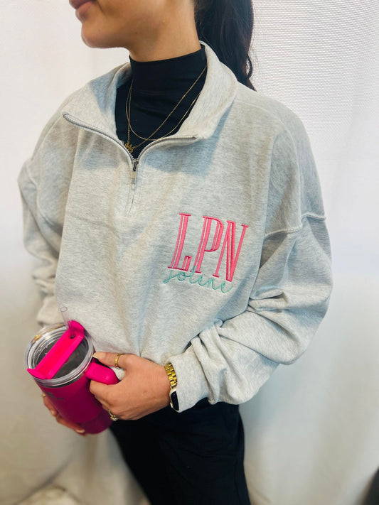 Person wearing a gray sweatshirt with 'LPN' and holding a pink water bottle.